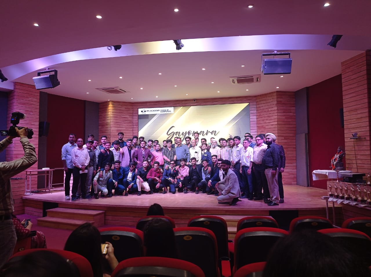 Group photo on stage in auditorium