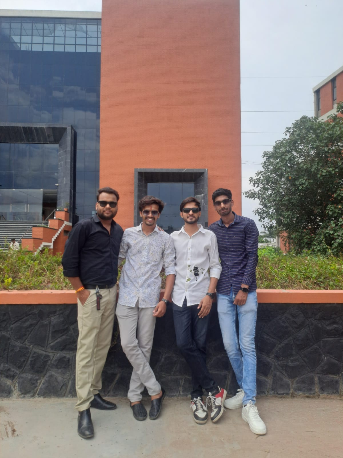 Four friends smiling on campus